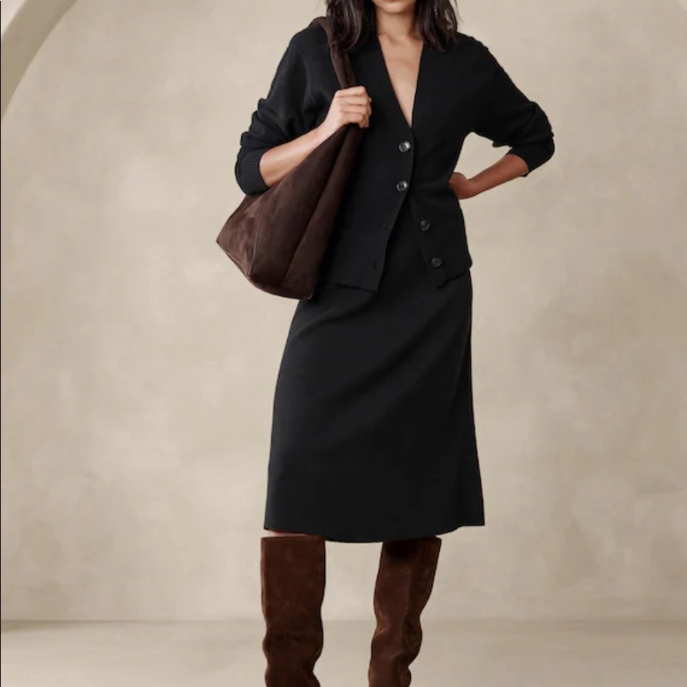 Black sweater skirt with slit in front.